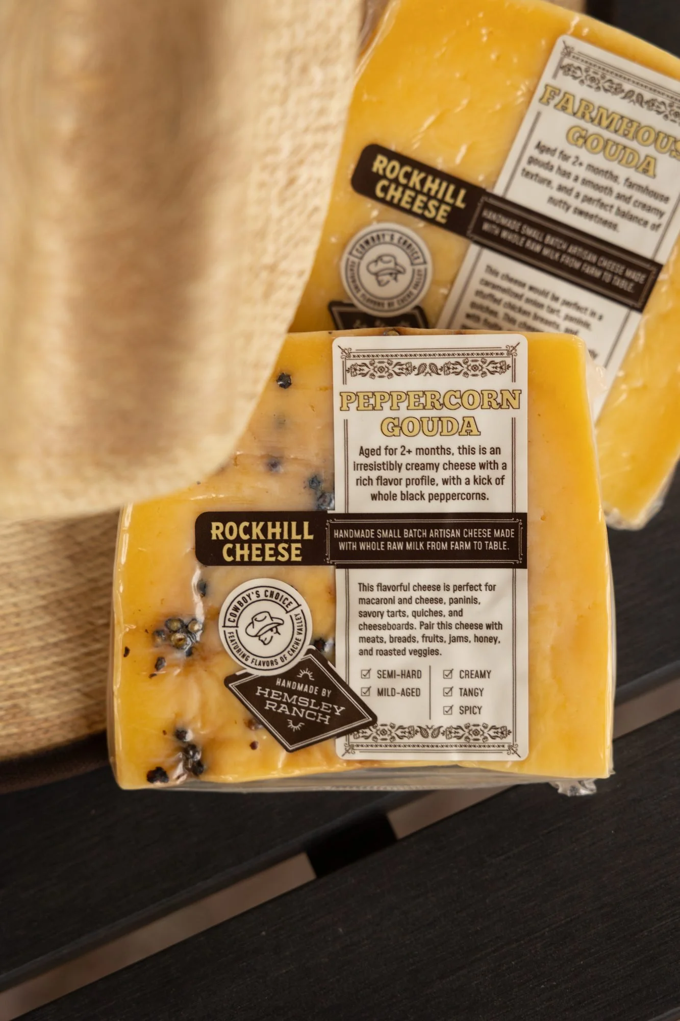 Close view of labelled Rockhill Cheese wedges tucked under the brim of a straw hat