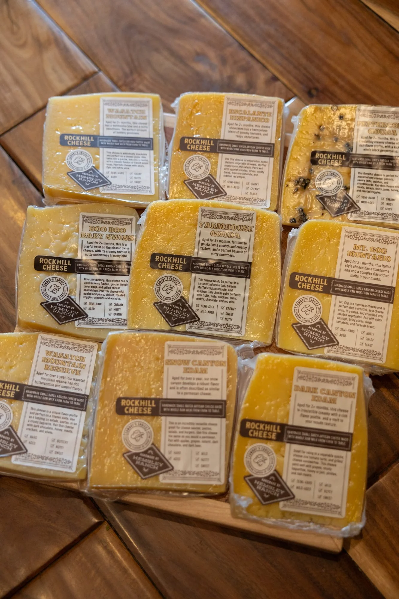 Rows of wrapped Rockhill Cheese wedges with printed labels on a wooden surface