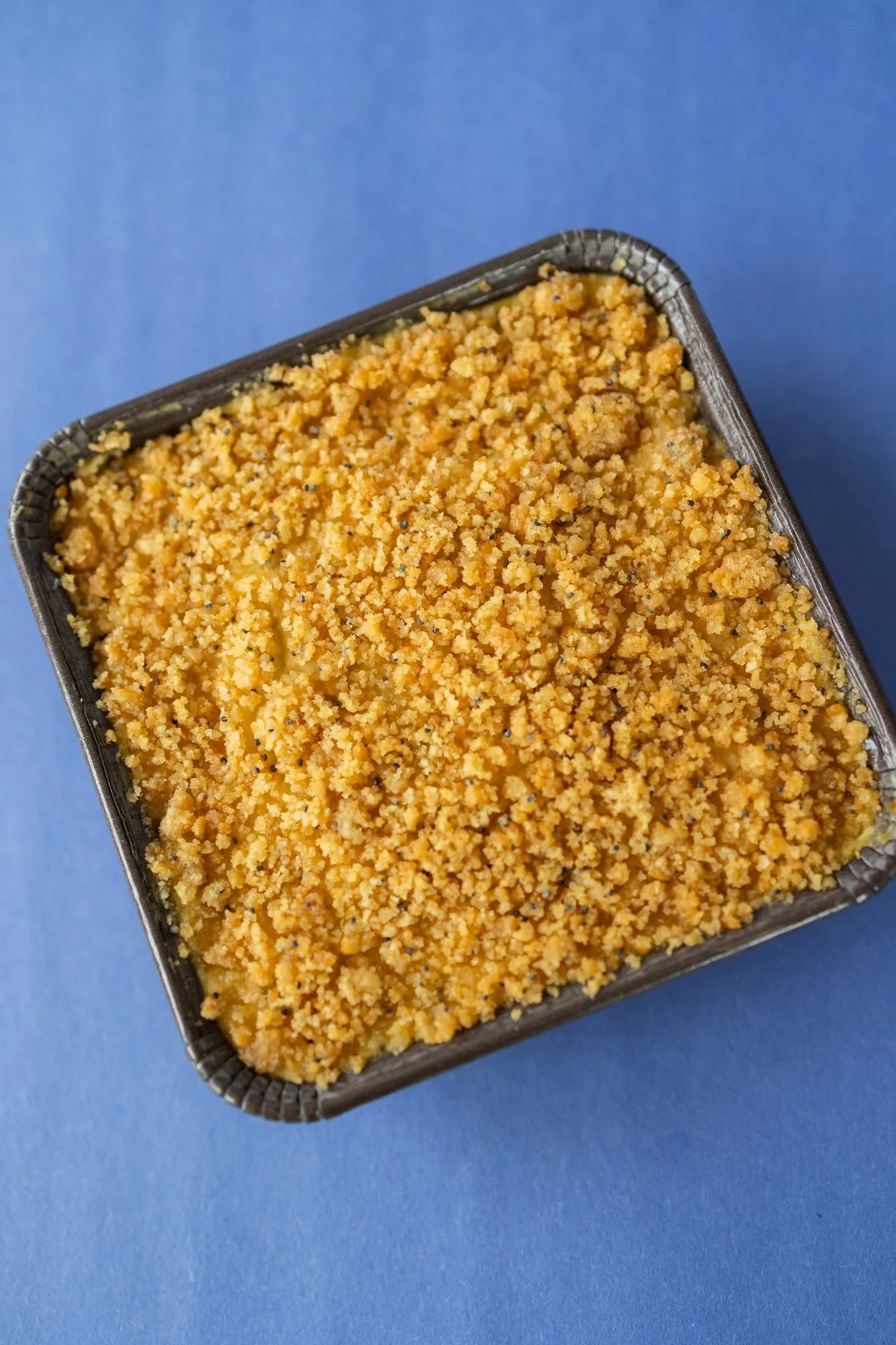 A crumb-topped casserole on a blue background
