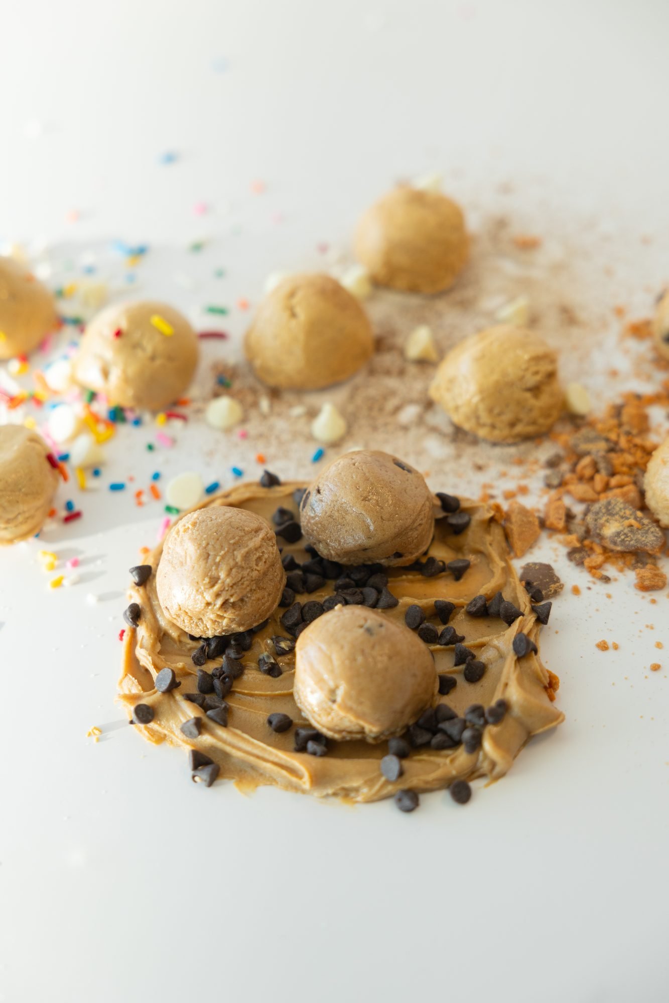 Cookie dough balls scattered with sprinkles and peanut butter
