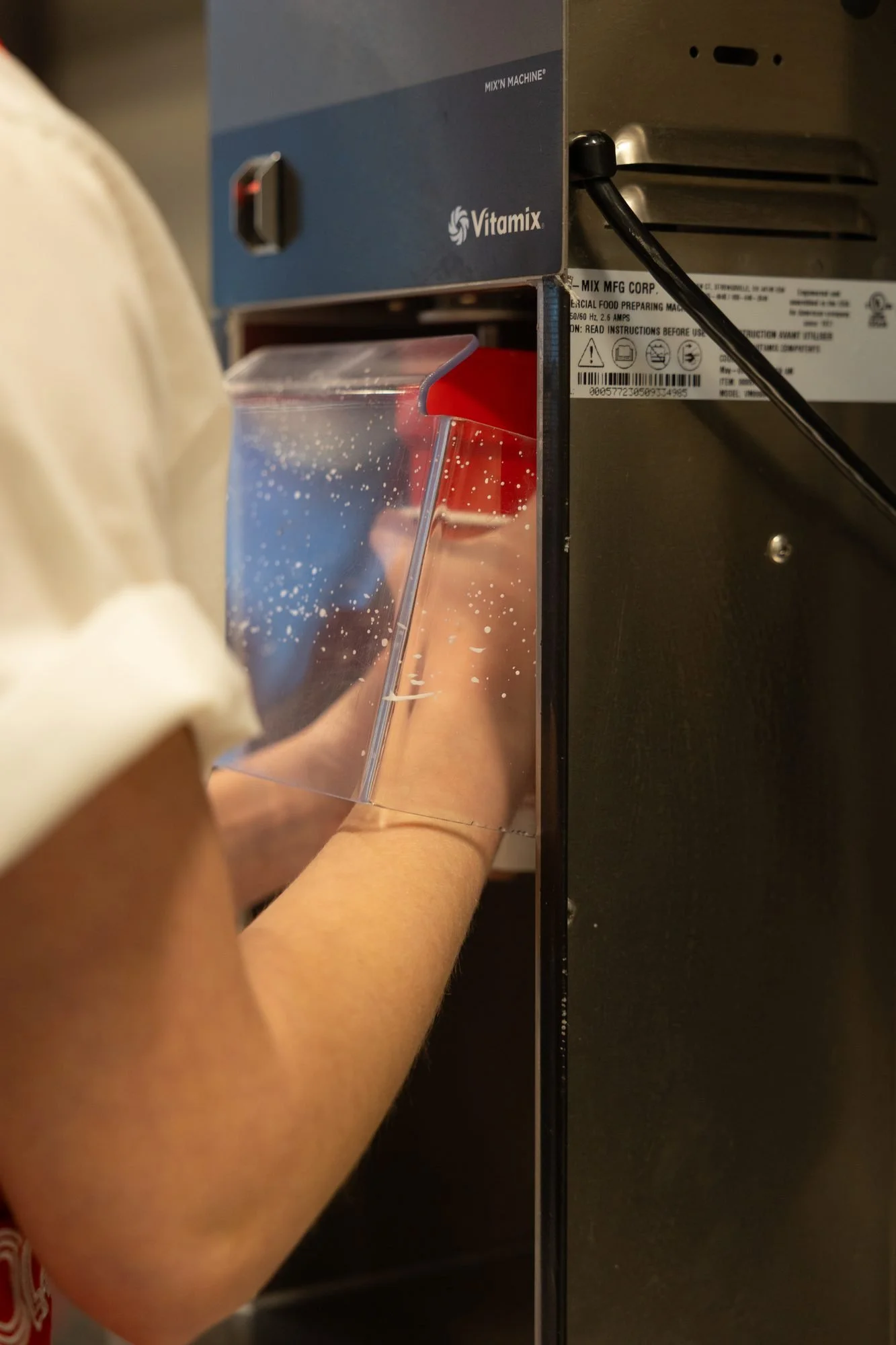 A Polar Bear employee pours a shake from a steel blender cup