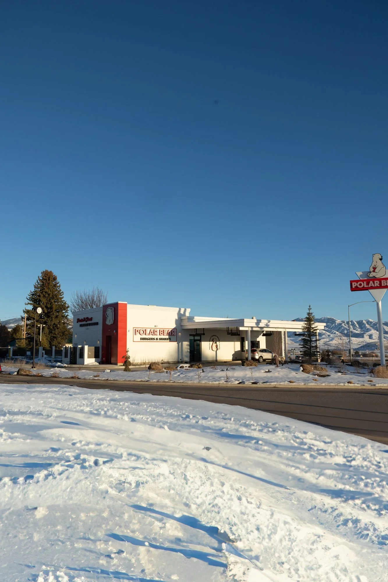 A Polar Bear restaurant building seen across a snowy lot under a clear blue sky