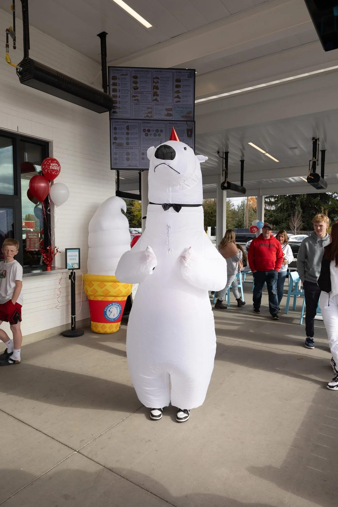 A person in a polar bear costume greeting customers outside the Polar Bear order window
