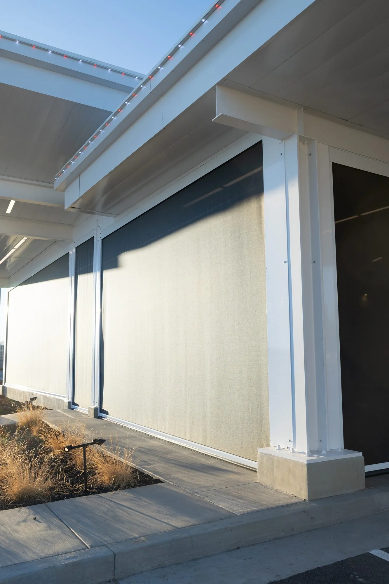 The white covered walkway along the side of a modern restaurant building