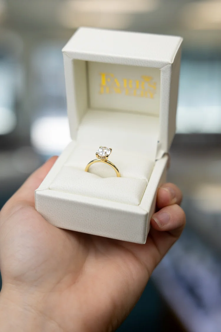 Diamond ring in an open Farr's Jewelry box, held up in the Ogden store