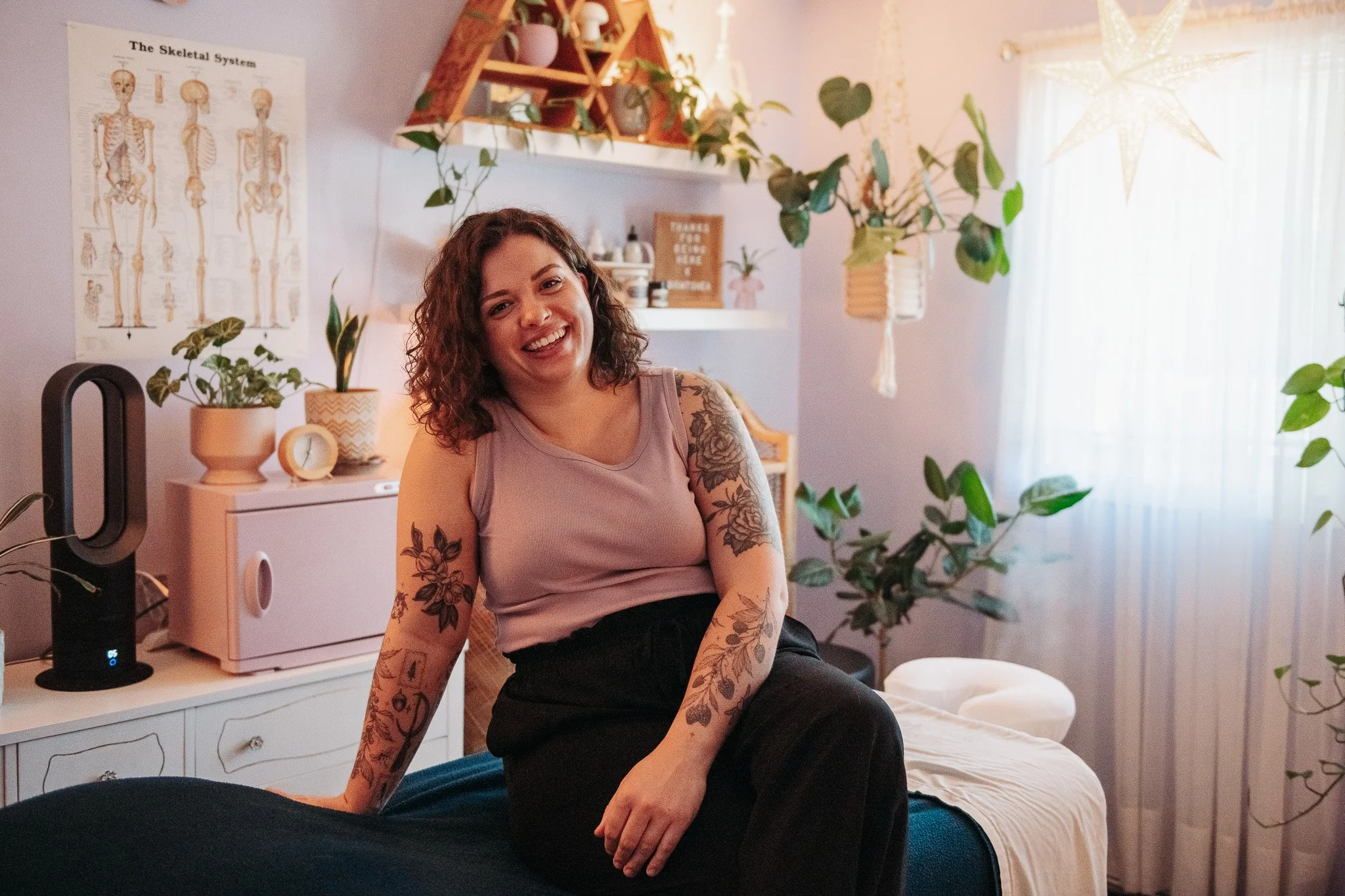 a woman smiling in a warmly lit massage room
