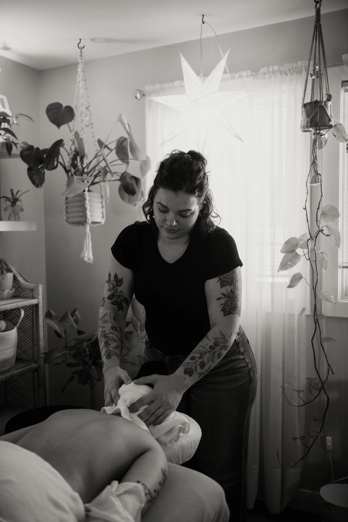 a massage therapist using a hot towel on a clients neck
