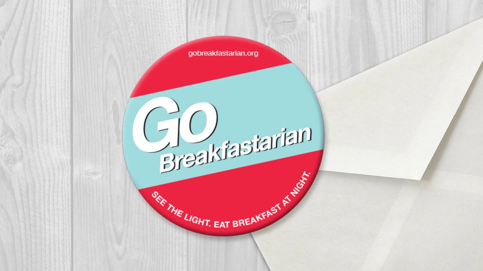 A round button with red and light blue sections, displaying the words "Go Breakfastarian" and the website 'gobreackfastarian.org', with the phrase "See the light. Eat breakfast at night" at the bottom.