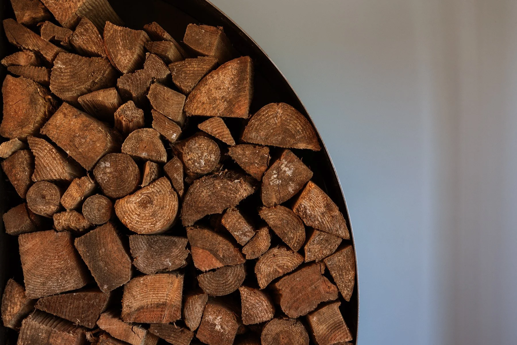 Stacked chopped firewood logs in a semi-circular shape.