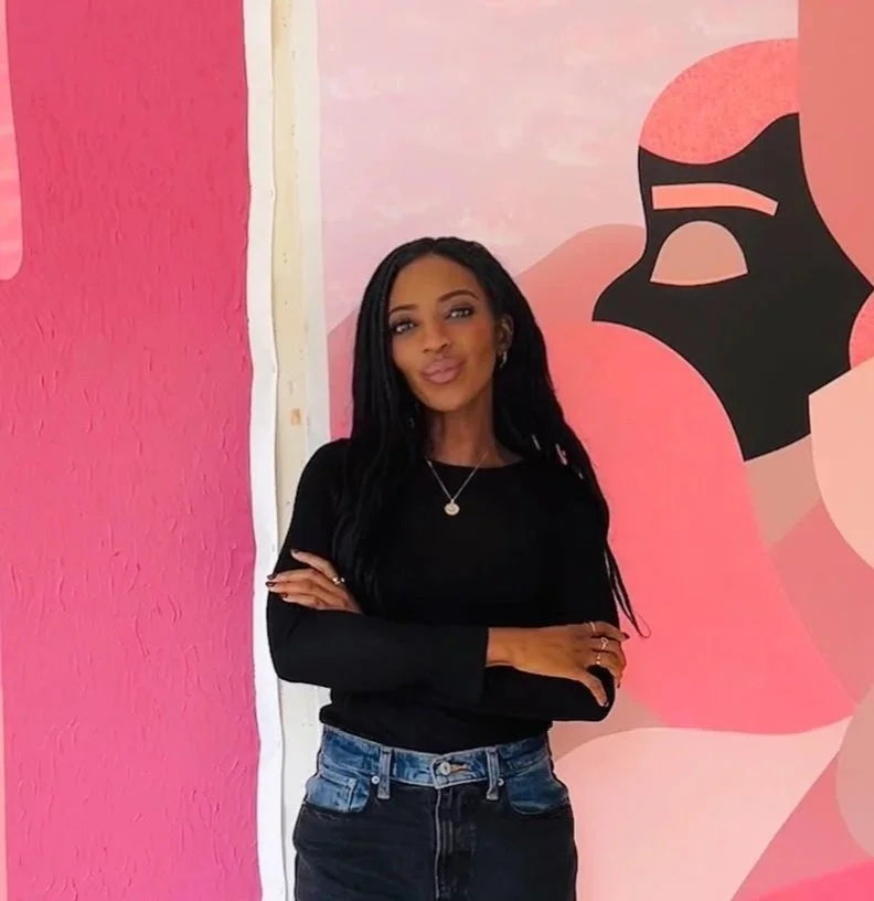 Woman in black standing in front of art work 