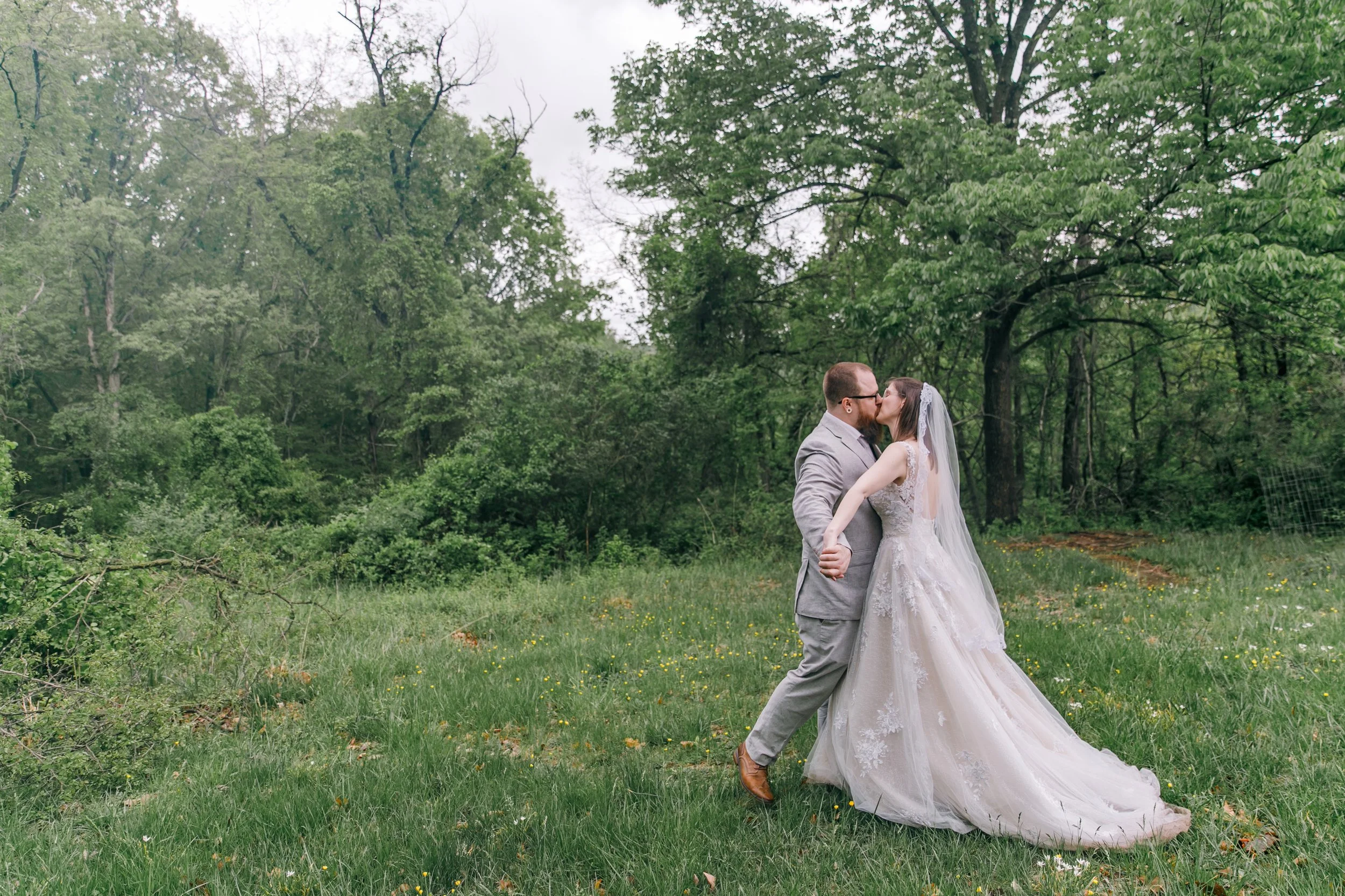 A bride and groom kissing in the field at their park elopement in Maryland.