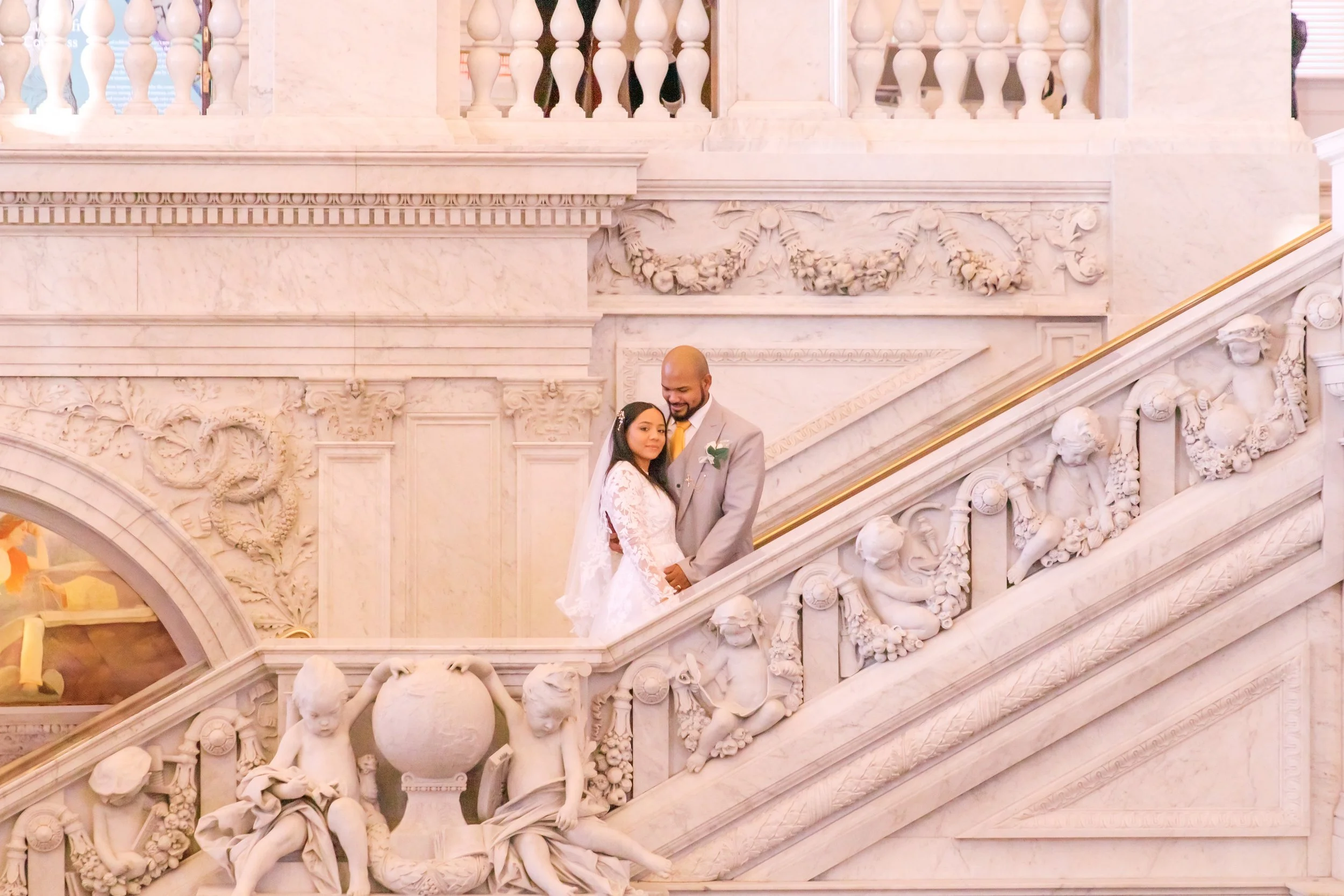 A bride and groom posing elegantly on the steps of the Library of Congress in Washington DC.