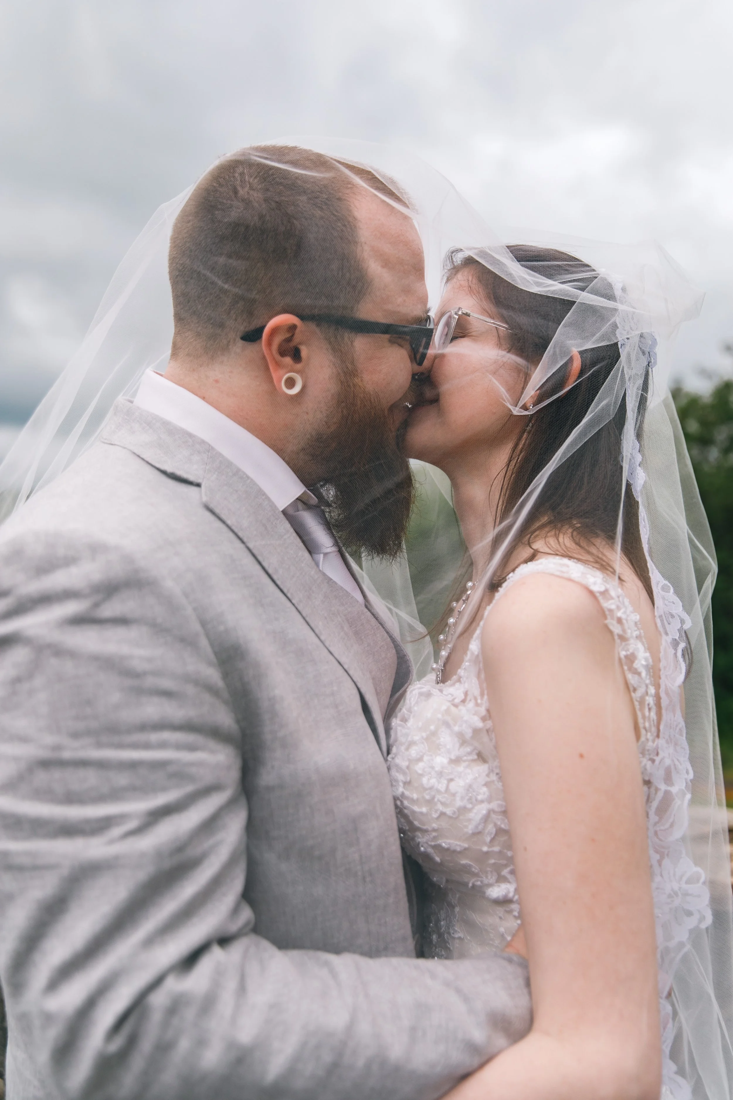 A couple sharing a joyful kiss under the veil after their elopement in Maryland.