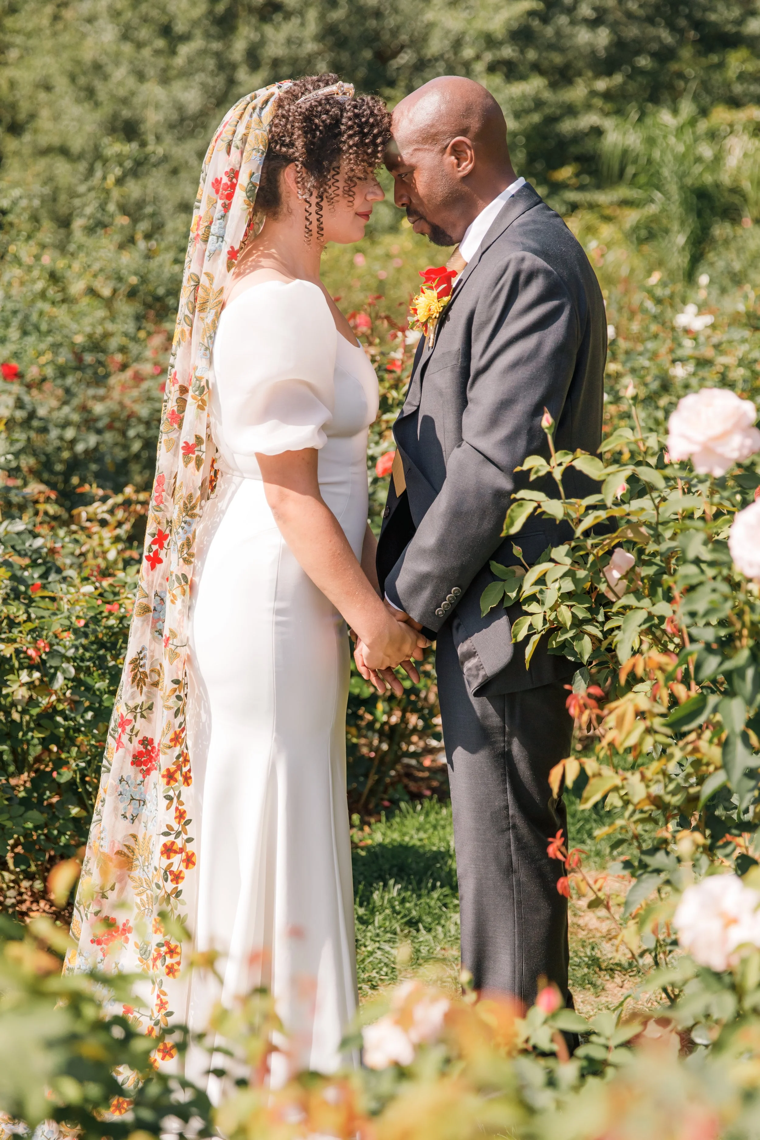 A couple touching foreheads before eloping in Virginia at the Bon Air Rose Garden.