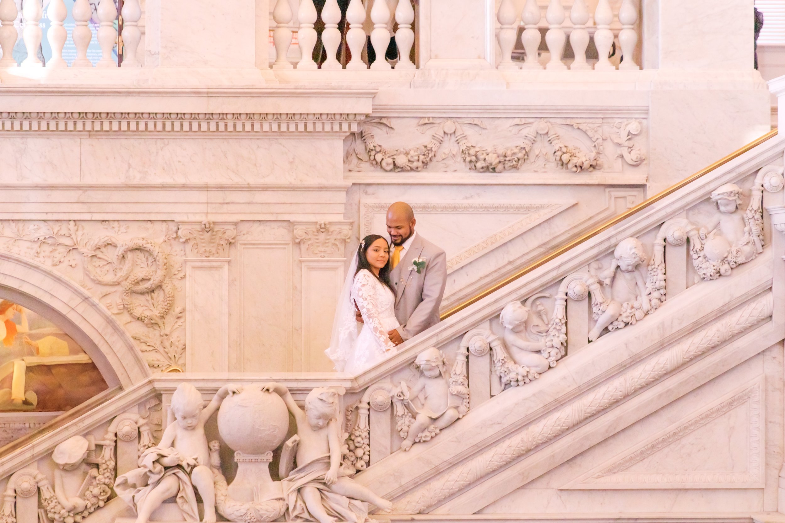 A bride and groom standing on the elegant staircase of the Library of Congress in Washington DC.