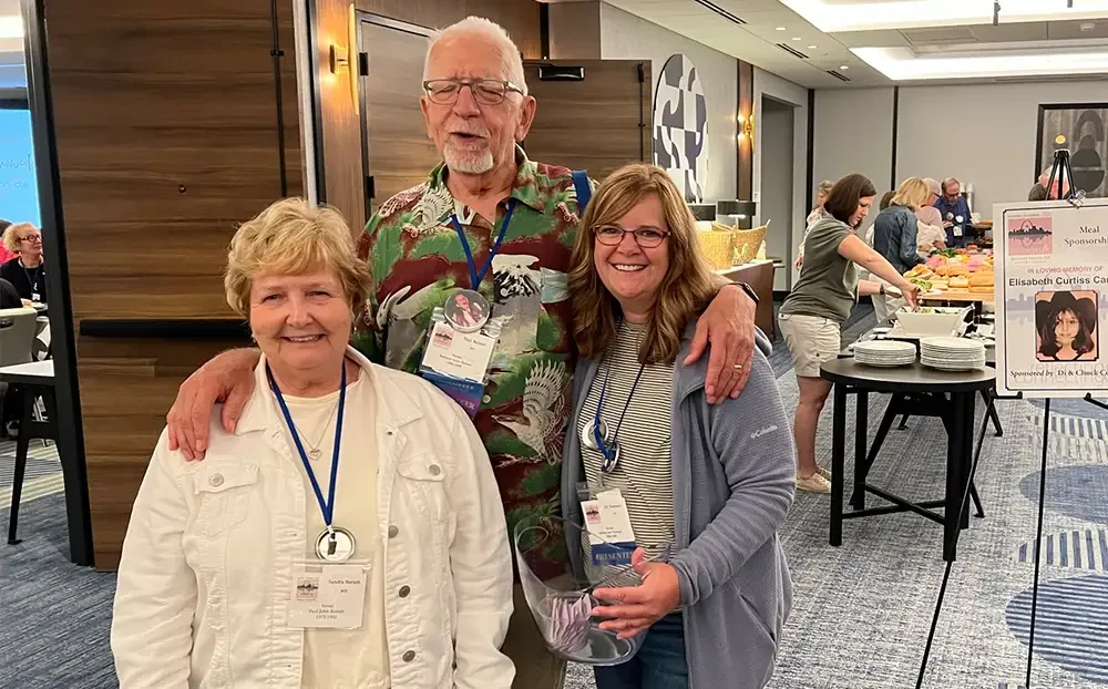 three people smiling and standing together