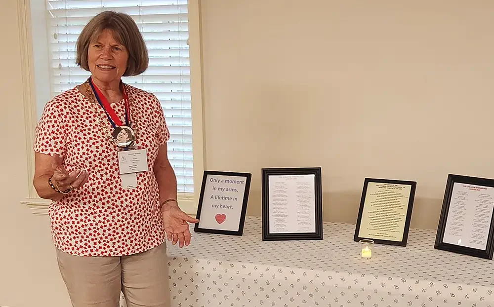 woman standing at front with photos behind