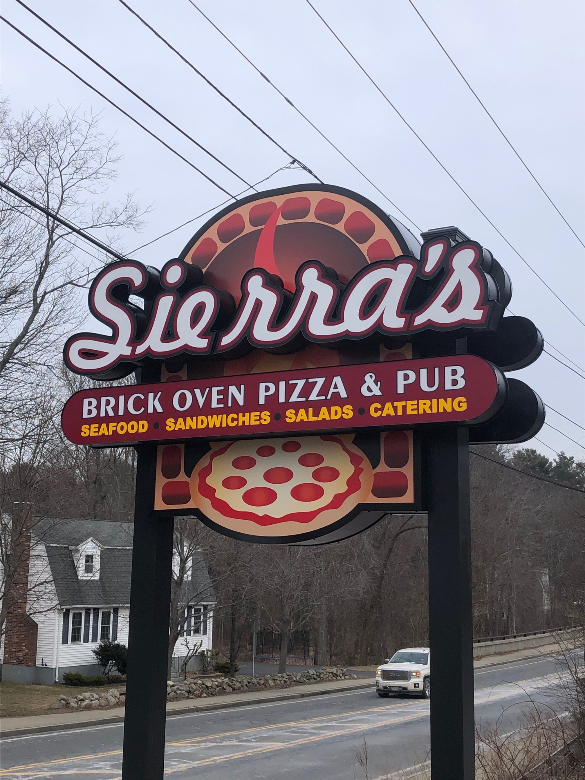 Expertly crafted sign for Sierra's restaurant advertising brick oven pizza and pub, with offerings of seafood, sandwiches, salads, and catering.