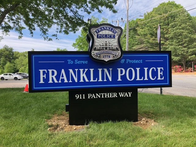 Blue sign for Franklin Police with a police badge crest at the top, located on Panther Way