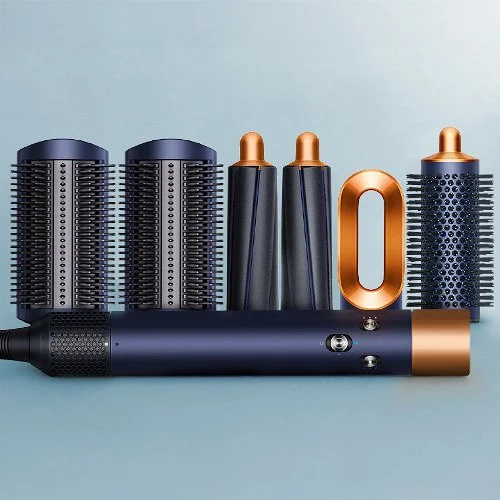A collection of hair styling tools including a hair dryer with attachments, a diffuser, a concentrator nozzle, and a straightening comb, all on a light blue background. Photo composite made by Alexis Kush Creative using stock and product photographs.