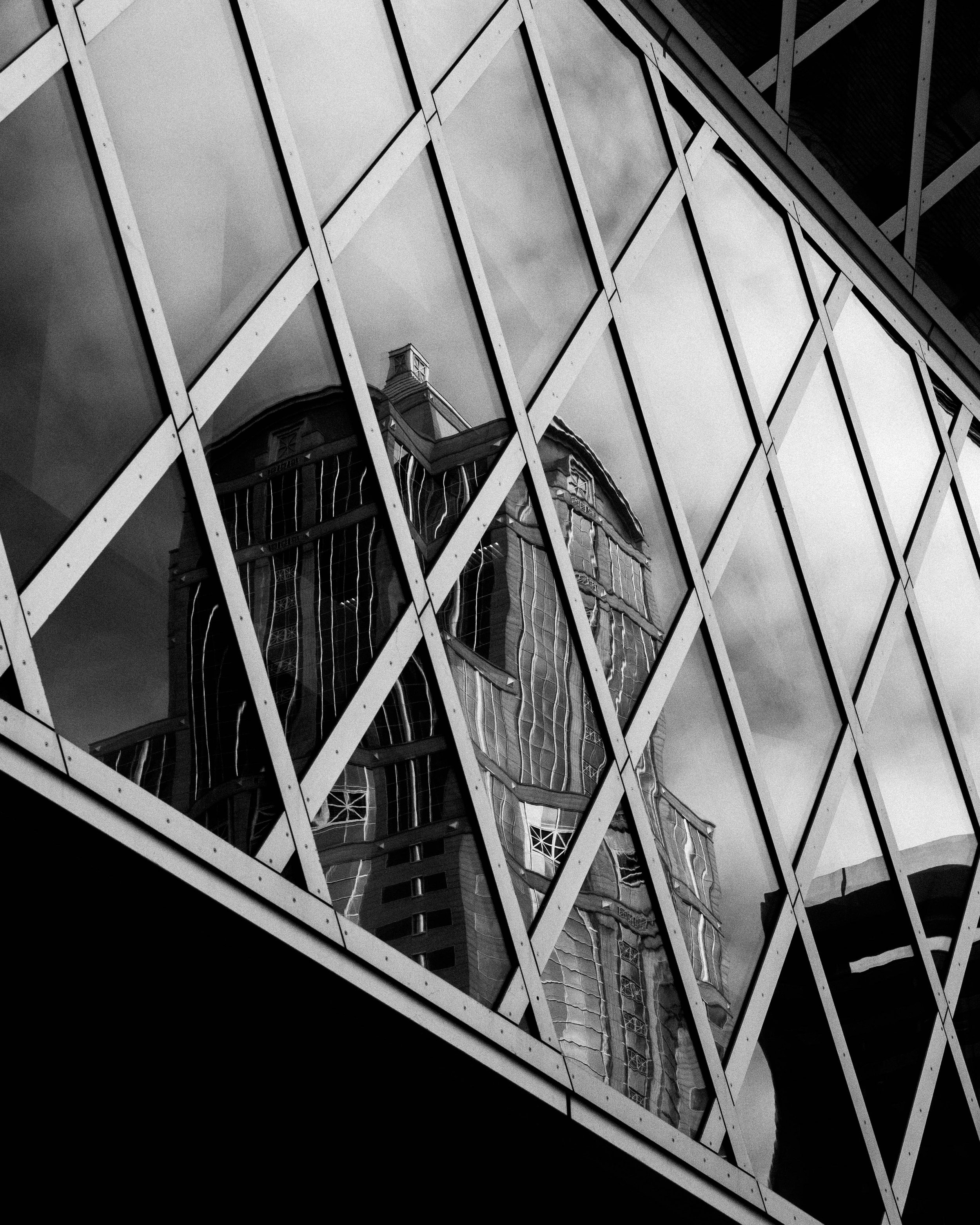 Reflection of a historic building with ornate details on a modern glass building facade