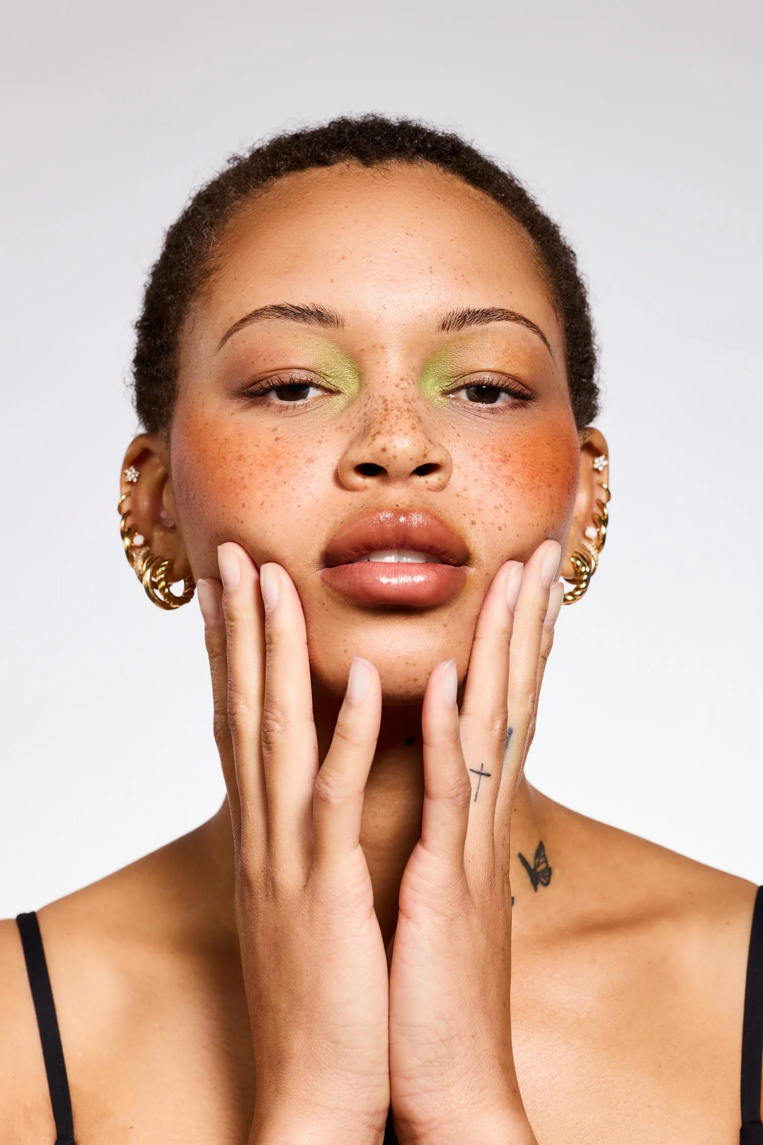 Minimal beauty portrait with green eyeshadow and hands on face for clean skincare branding