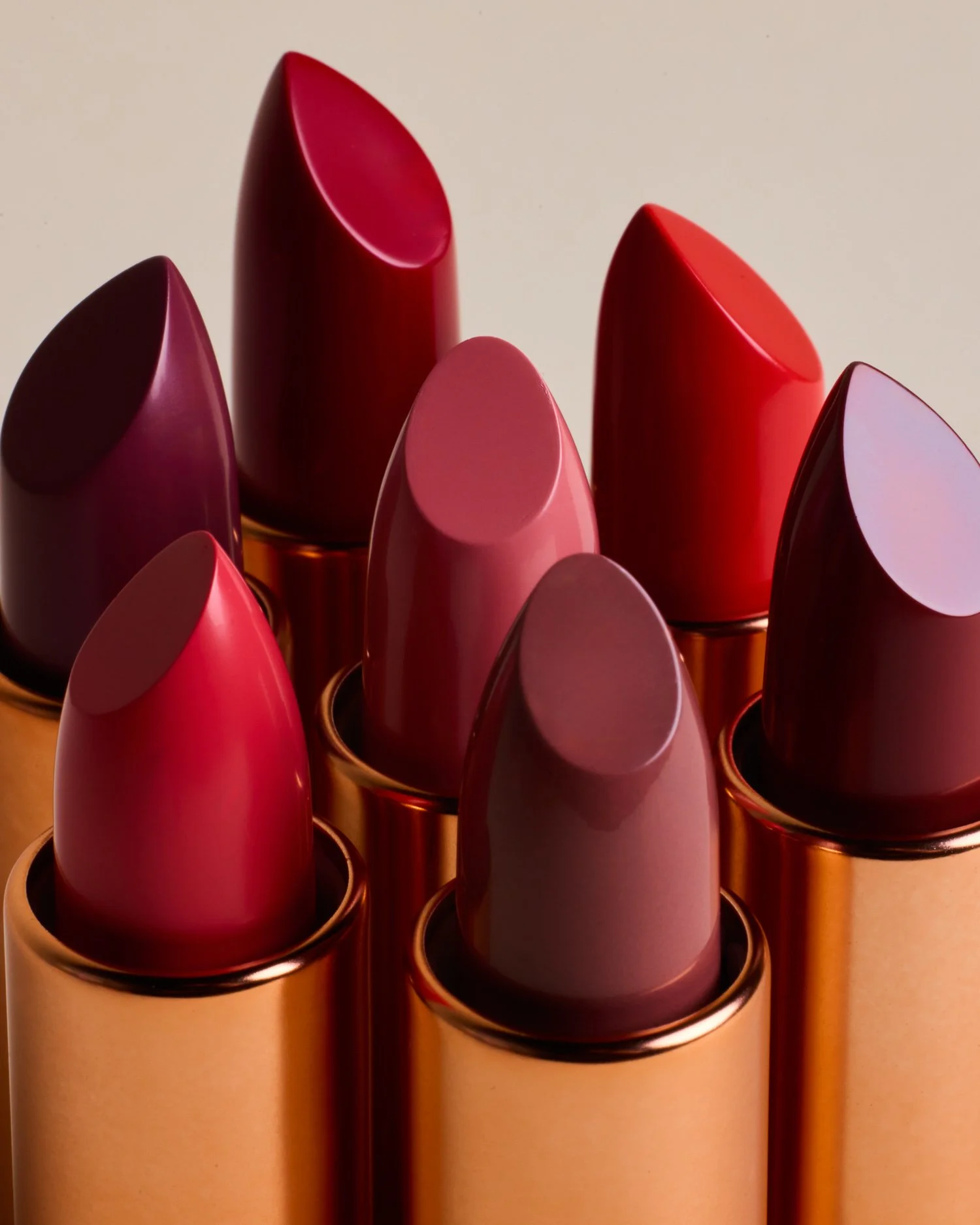 Bold red lipstick flat lay with luxury metallic tubes — beauty product photography in Los Angeles