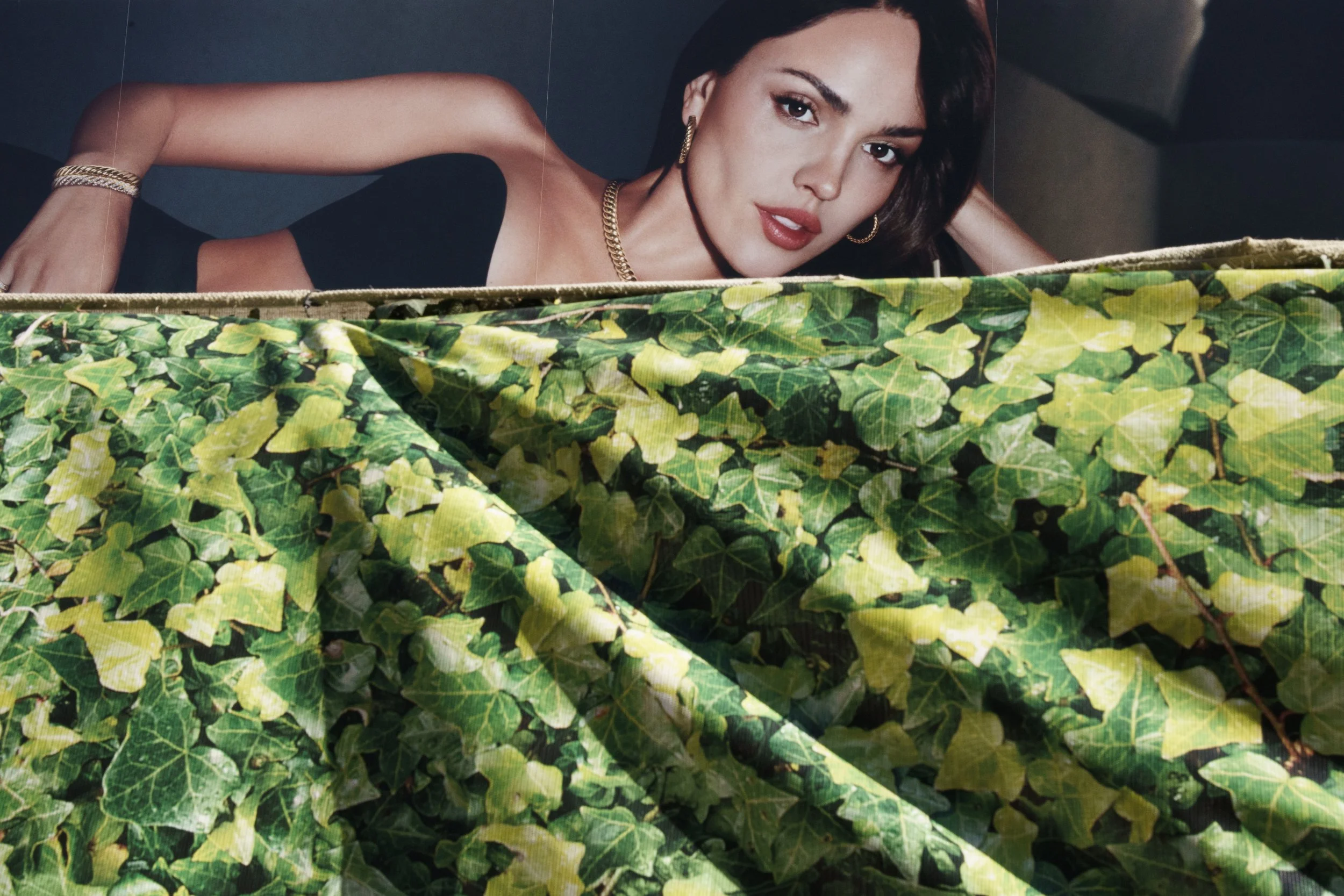 A billboard overlooking a wall of printed greenery in NoHo.