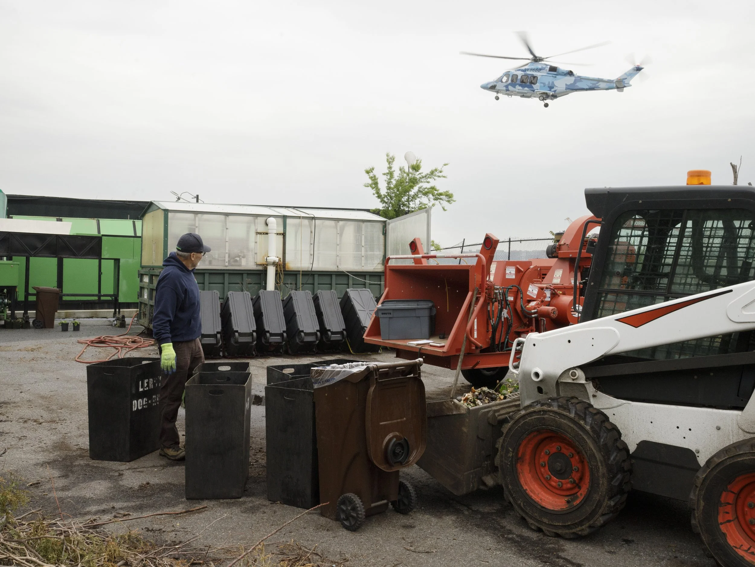 While David works, a helicopter lands nearby. Due to his own concerns about pollutants from the nextdoor heliport and road, David recently stopped planting vegetables in the compost yard garden.