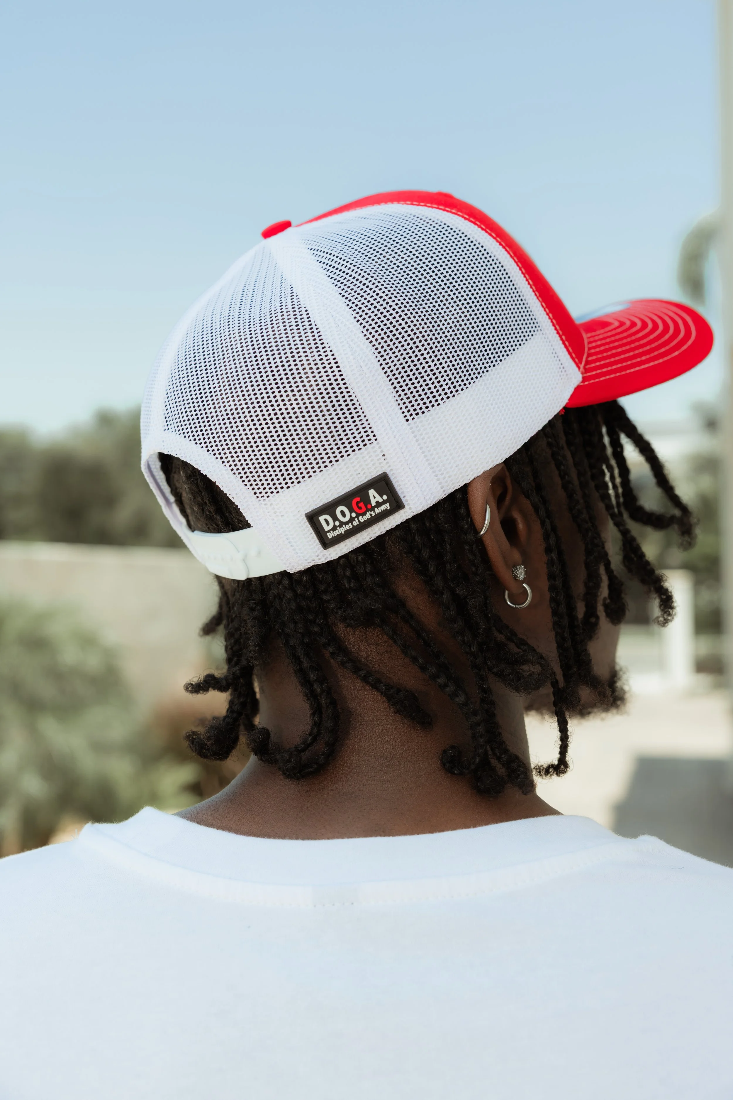 A red and white trucker hat with a D.O.G.A. branding. 