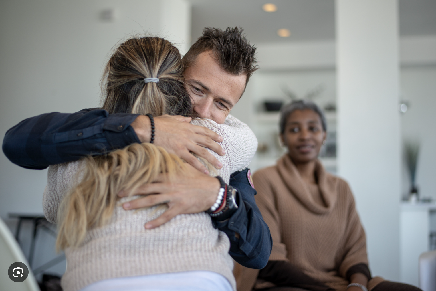 Two people hug during mental health session