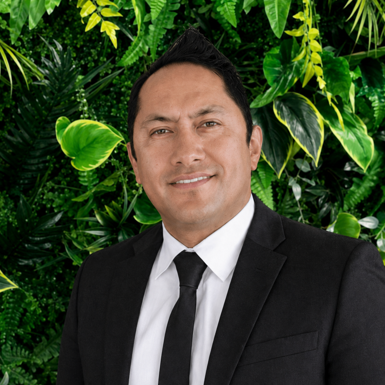 Portrait shot of Aroha Page, Office Manager of Simplicity Funeral Home in Hamilton, in front of a greenery backdrop.