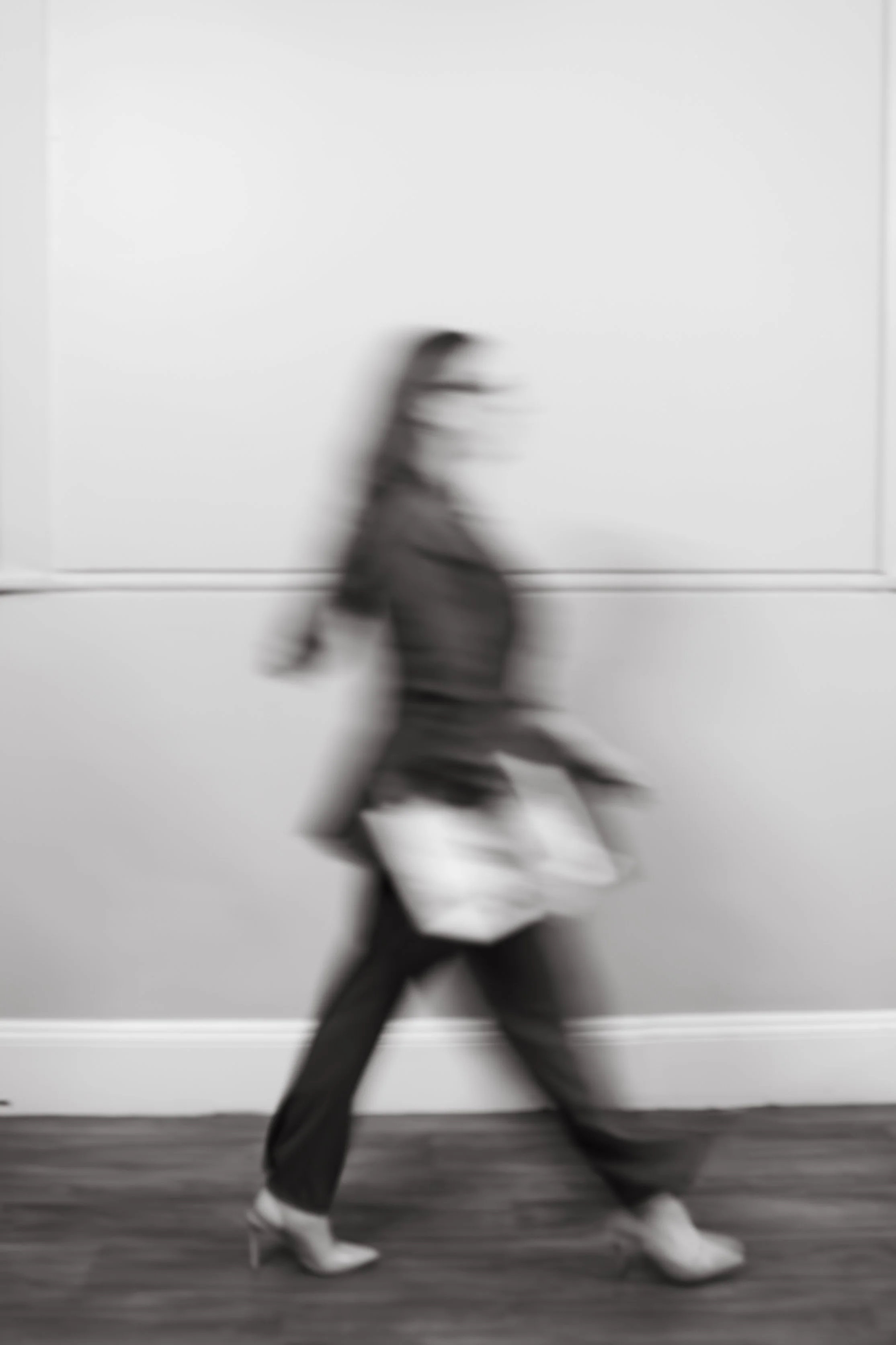woman walking holding laptop in motion blue black and white