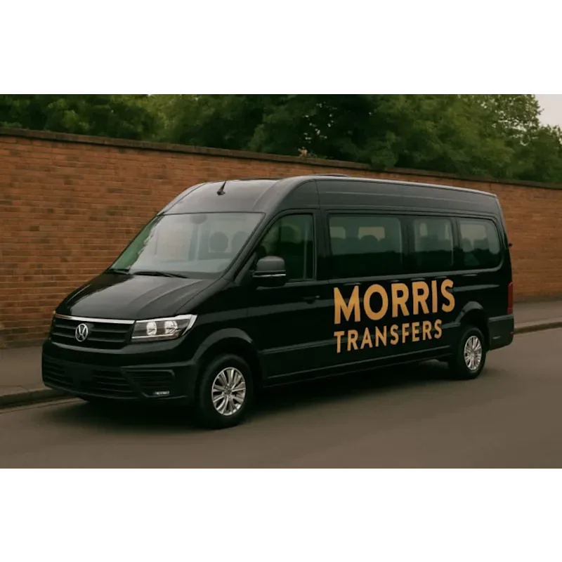 A black Morris Transfers minibus parked on a quiet street, featuring gold “MORRIS TRANSFERS” branding on the side. The vehicle is a modern passenger minibus used for airport transfers, school transport, and private hire services in the UK.