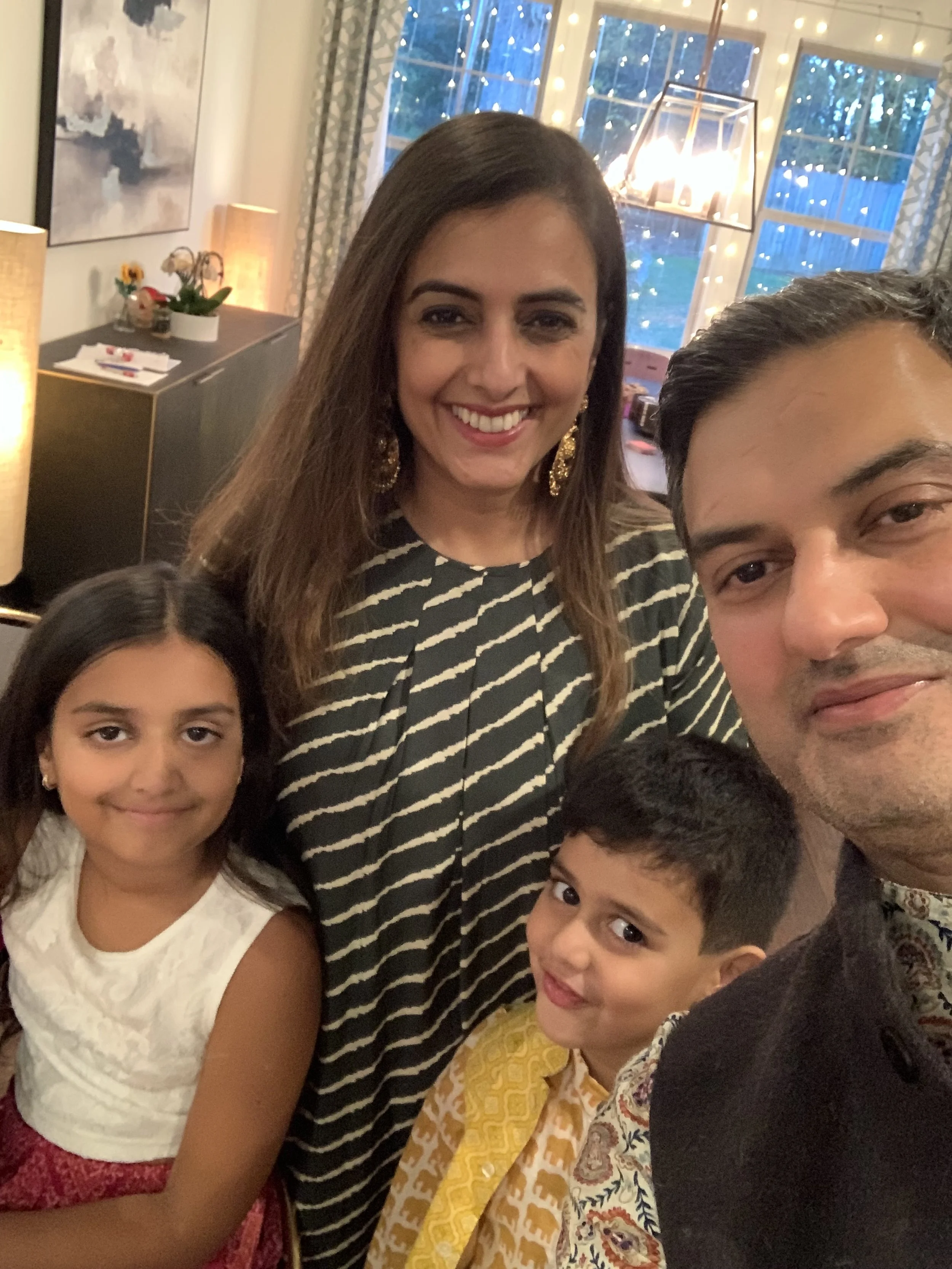 Namrata, her husband, her daughter, and her son smiling.