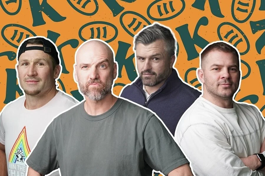 Four men standing in front of a background with an orange and teal pattern of stylized footballs and the word 'KICK.'