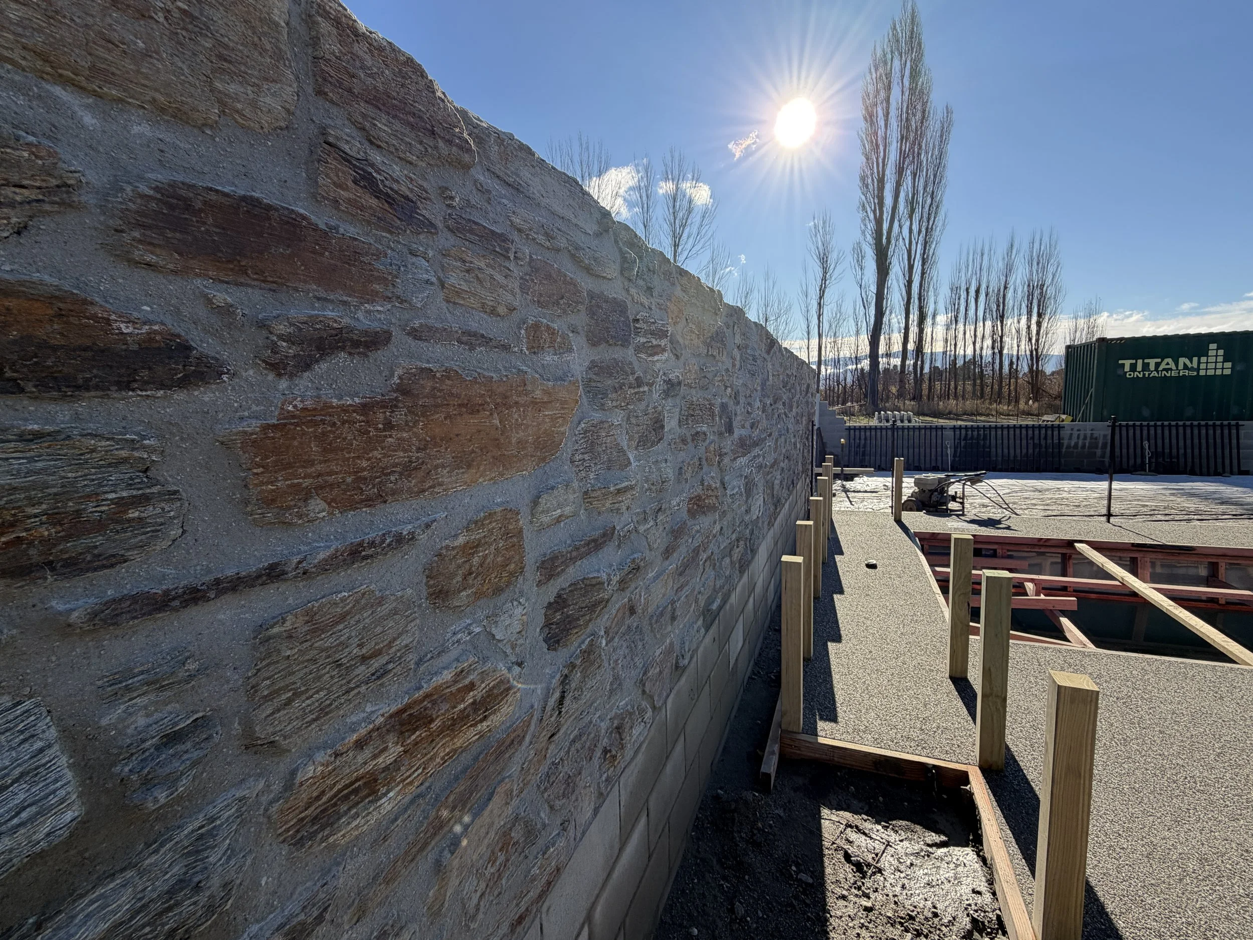 Schist stone wall detail at a contemporary Central Otago home designed by Candela Architecture, showcasing natural stone cladding, jumping stones, and traditional masonry principles.