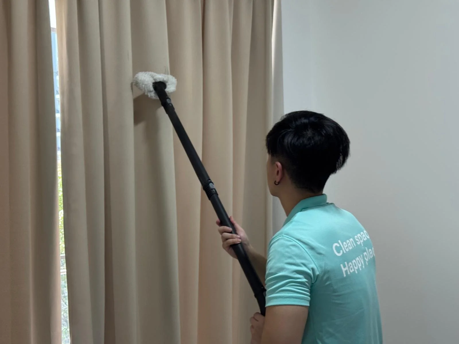 Cleanova Pte Ltd staff steam cleaning the curtains.