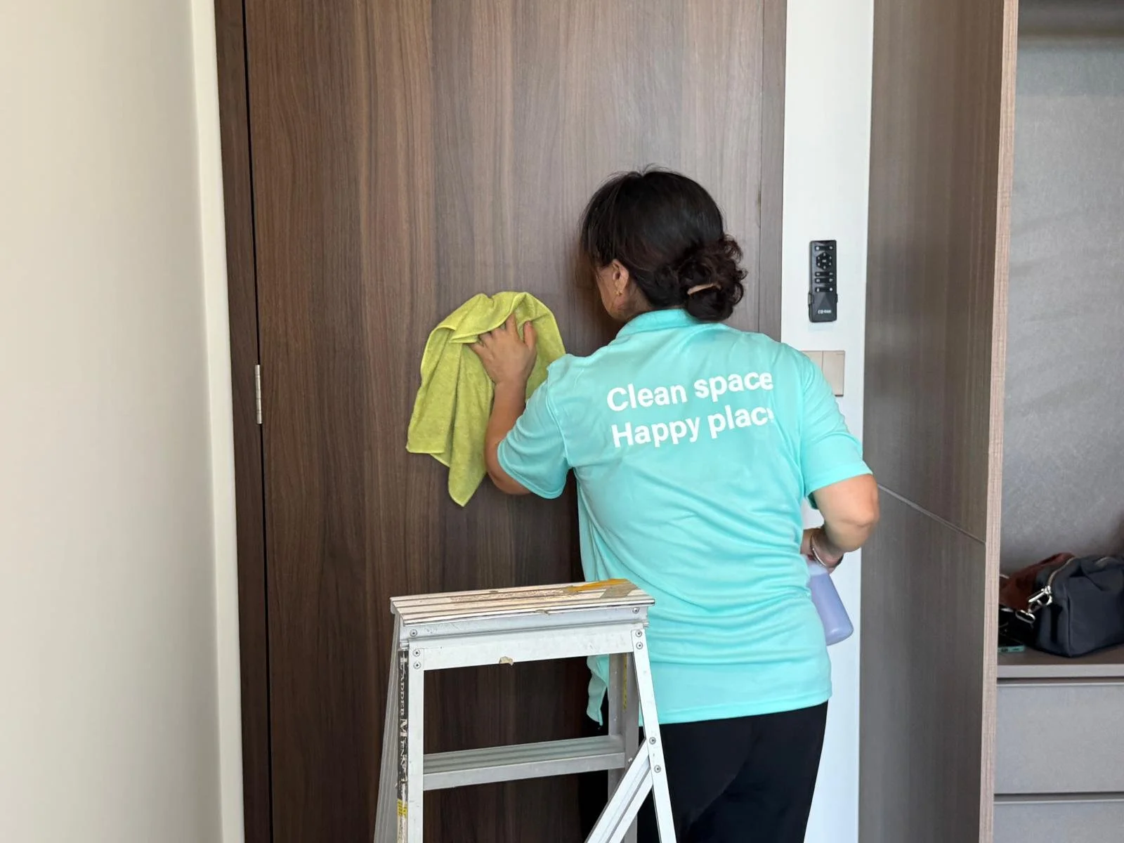 Cleanova Pte Ltd staff cleaning the door.
