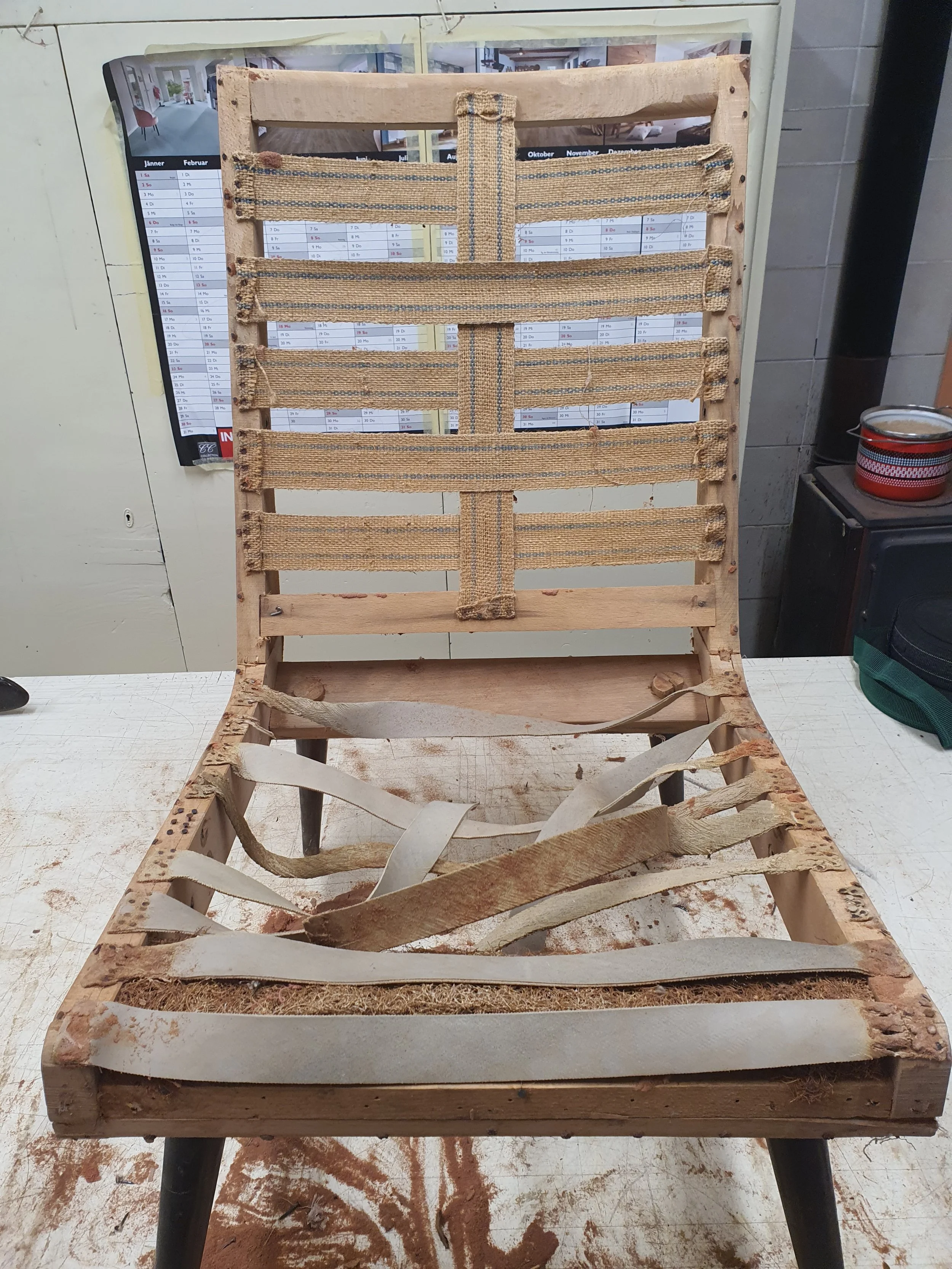 Ein Polstersessel in der Werkstatt während der Restaurierung