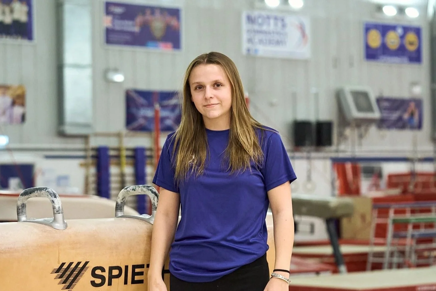 Silhouette of a man with a slicked-back hairstyle against a gradient purple-blue background.