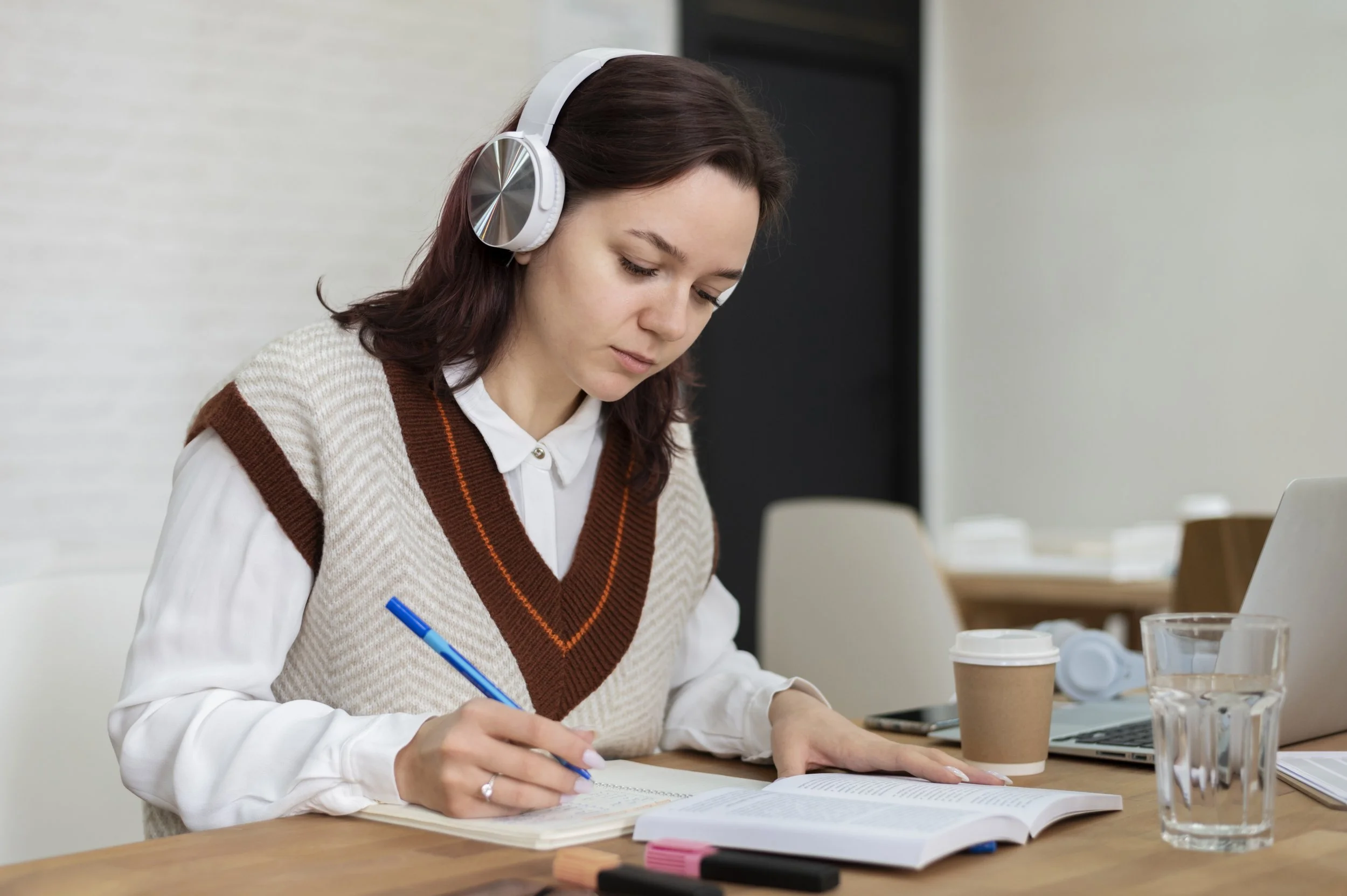 Student studying at a desk with books and laptop