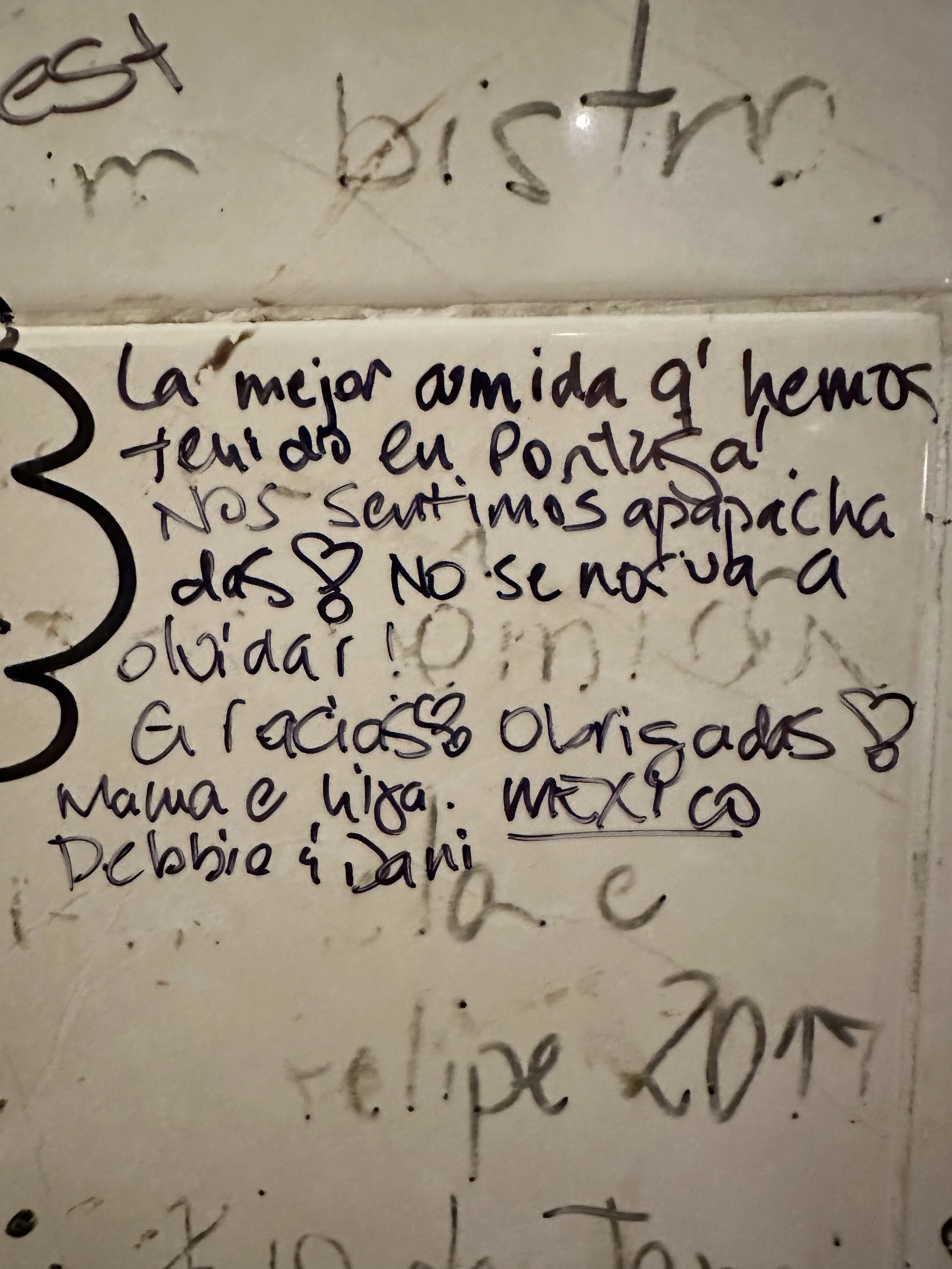Handwritten note in Spanish on a wall expressing gratitude and love to a mother with names signed at the bottom.
