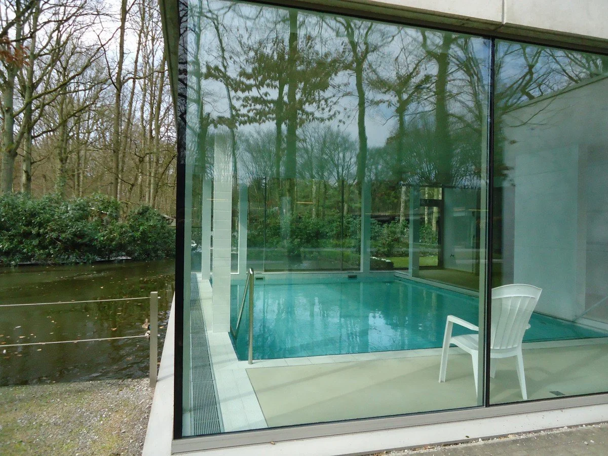 Private indoor heated swimming pool viewed through large glass windows, that is perfect for young children to learn how to swim.