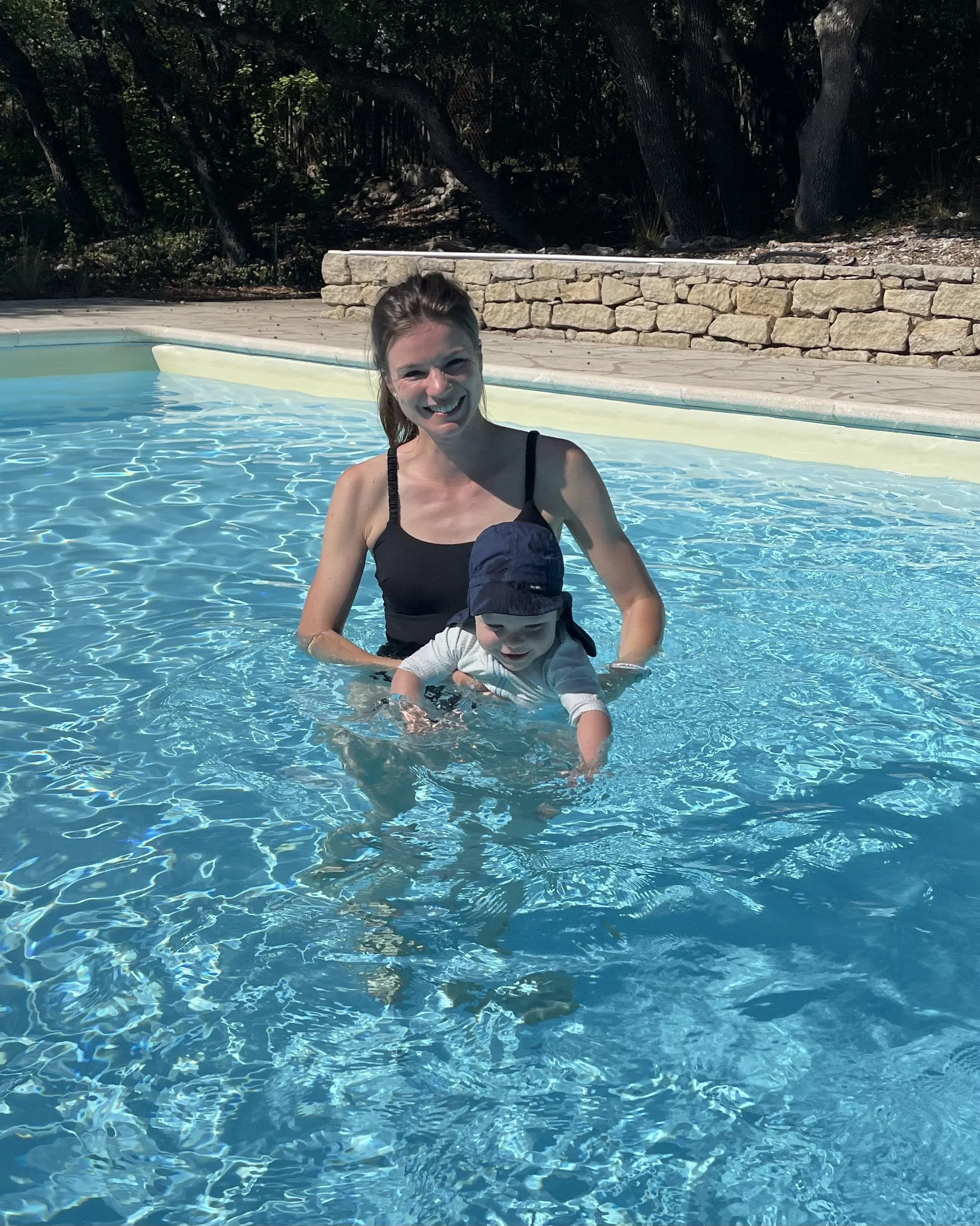 A woman and a young child enjoying a swim in a private heated pool. The woman is the swim teacher who learns the child to swim.