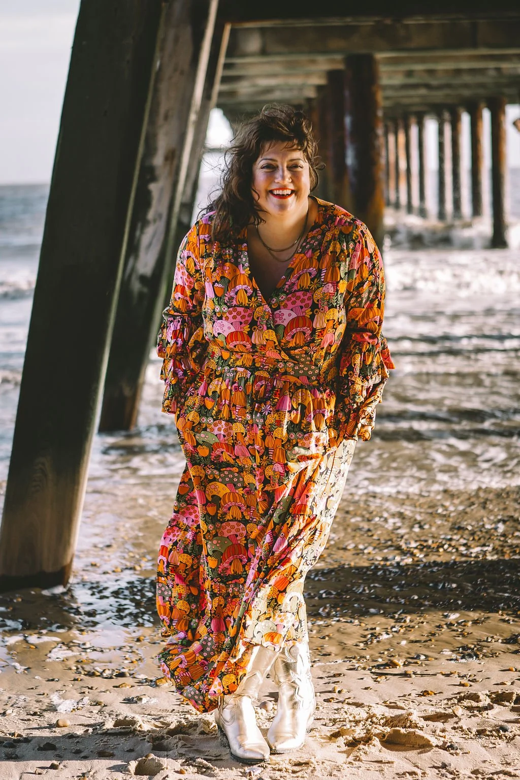 Ashleigh, wedding celebrant in bright mushroom dress and cowboy boots on the beach