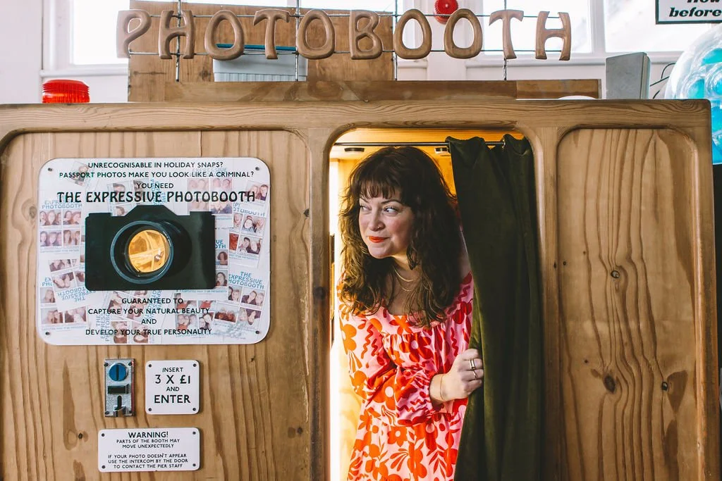 Ashleigh, wedding celebrant, peeping out of a vintage photo booth