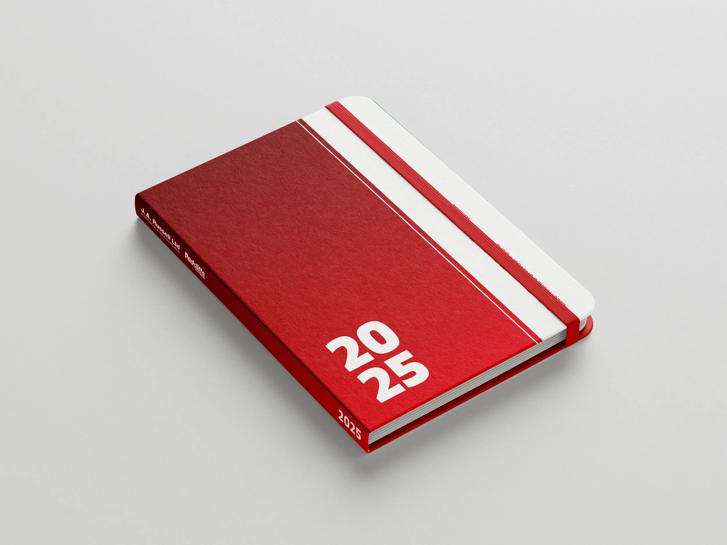 A red 2025 planner with white large text of 2025 on the cover, lying on a white surface.