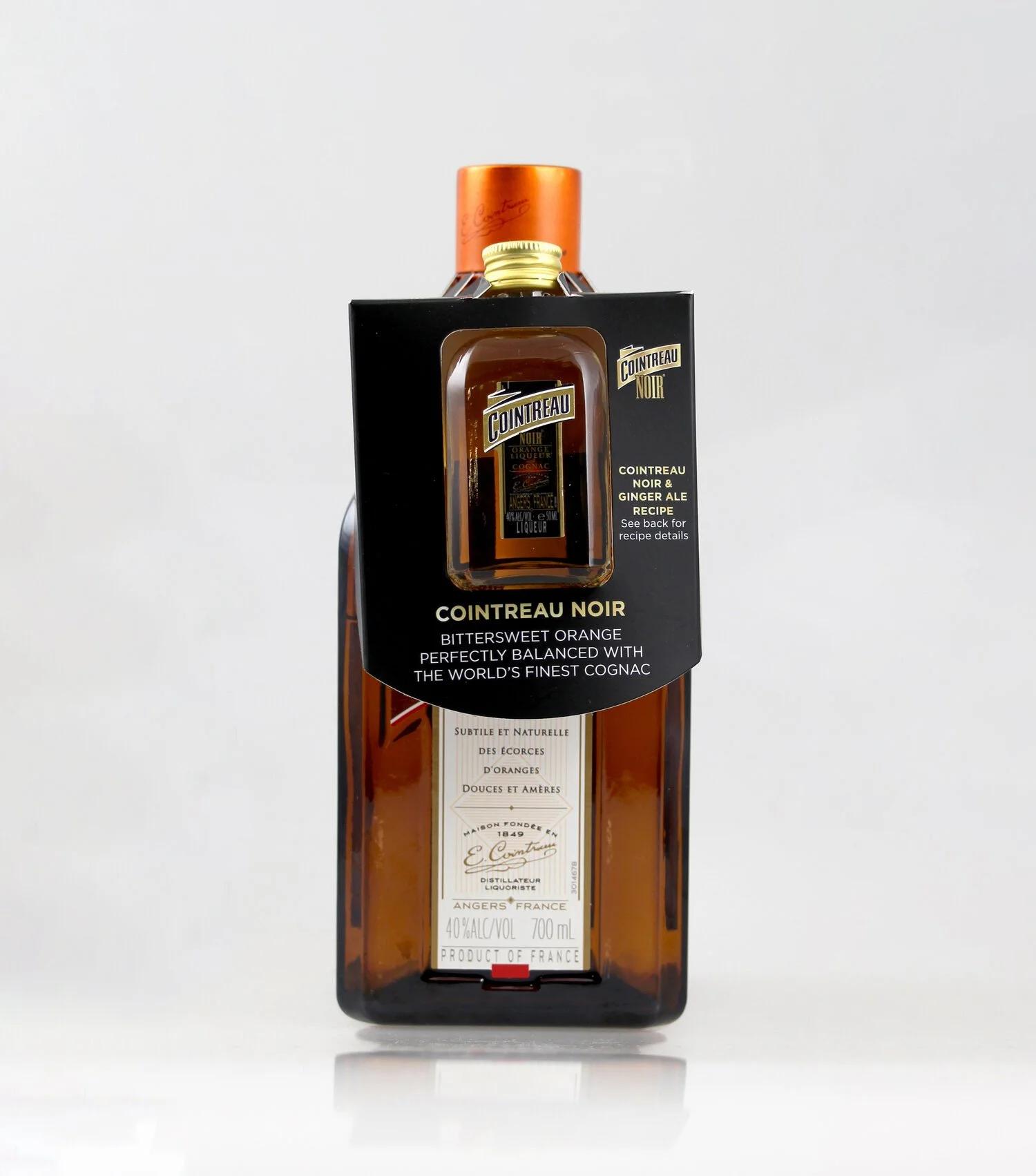 Bottle of Cointreau Noir with packaging describing it as bittersweet orange liqueur balanced with cognac, on a plain white background.