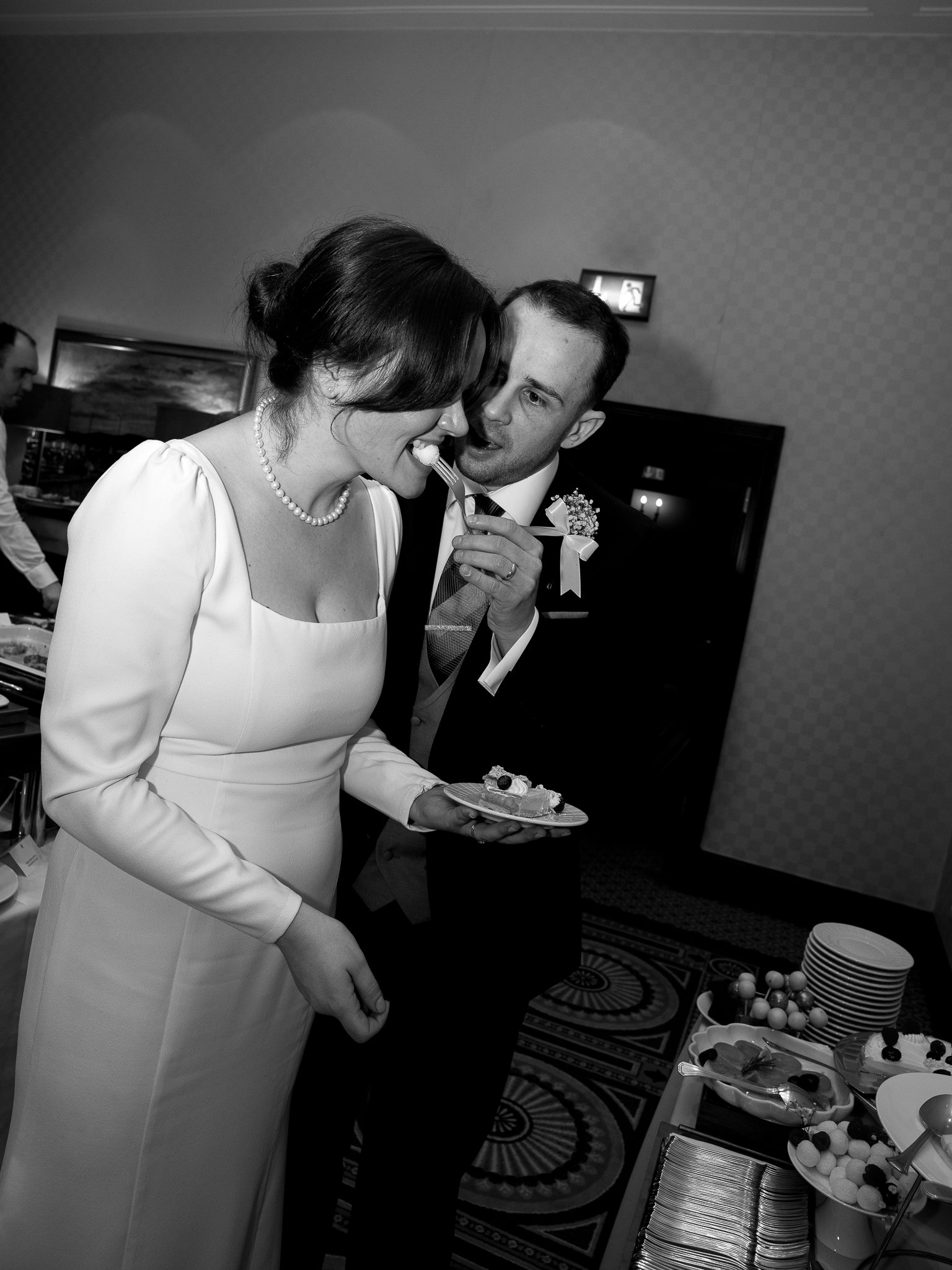A bride and groom at their wedding reception sharing a moment with a piece of cake.